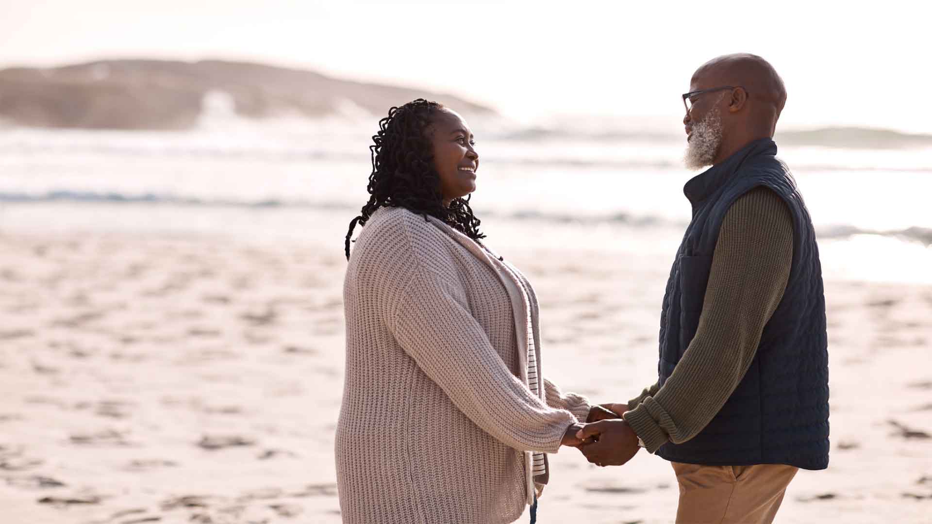A happy couple holding hands on a beach